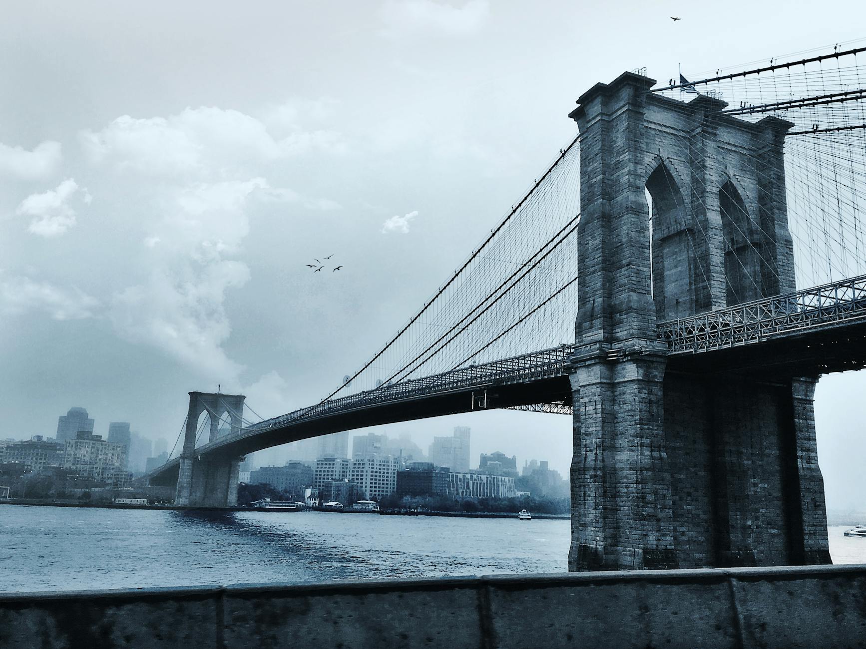 photo of suspension bridge under cloudy sky